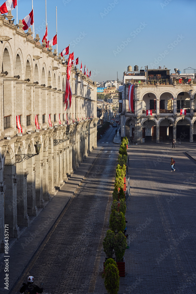Naklejka premium The symmetry and brightness of the Plaza de Armas never cease to amaze. Between the white volcanic stone and the patriotic decorations, this view captures the essence of Arequipa’s heritage and its en