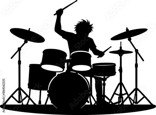 Silhouette of a young male drummer performing energetically on a drum set