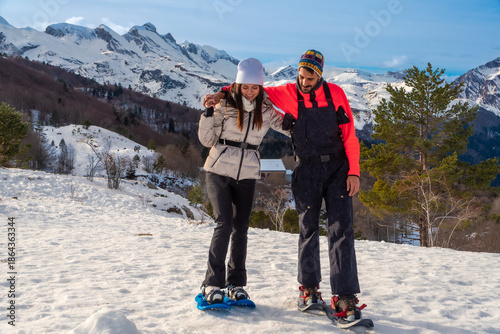 Couple snowshoeing in mountains with help and support