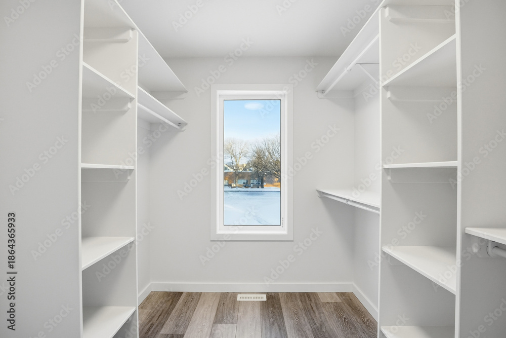 Fototapeta premium Small, empty walk in closet with a window