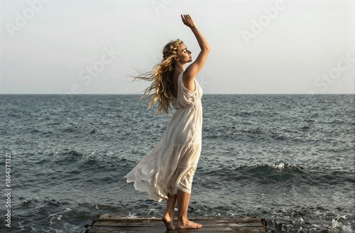 Woman in white dress feeling freedom by ocean