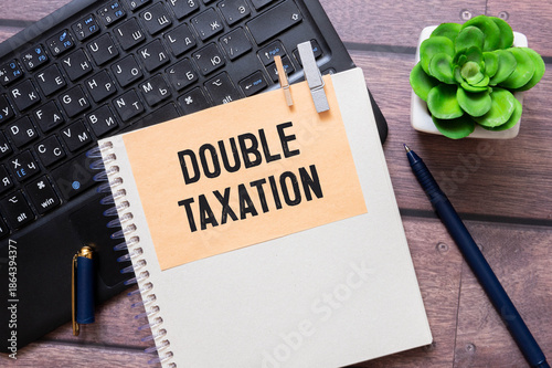 two notepads. open notepad with text DOUBLE TAXATION