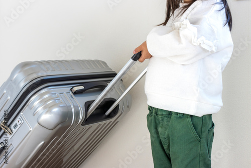 大きいスーツケースを持つ小さい女の子（5歳、日本人）