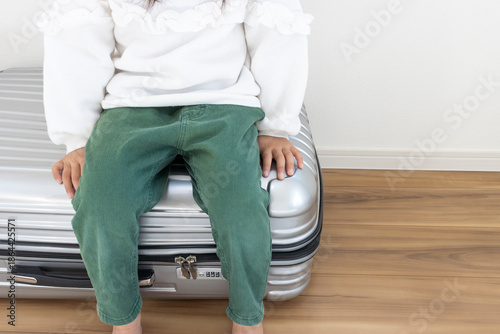 大きなスーツケースにちょこんと座る女の子（5歳、日本人、顔無し）