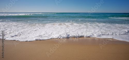 A beach seaside lifestyle backgound with horizon,surf waves, sand and sky elements and copy space