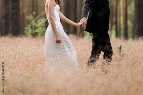 Photography Bride and groom holding hands in a peaceful forest meadow, intimate wedding moment surrounded by nature, symbolizing love, unity, romance, and a new beginning together