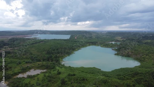Aerial view of a former coal mining pit that holds water like a blue lake, environmental damage