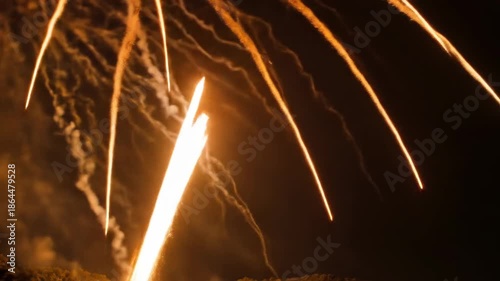 Streaks of golden light cascade down against a dark, atmospheric background.