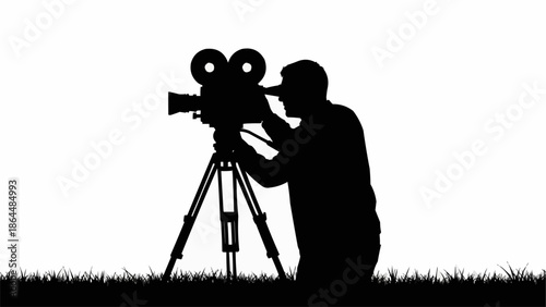 Silhouette of a filmmaker operating a vintage movie camera on a tripod.