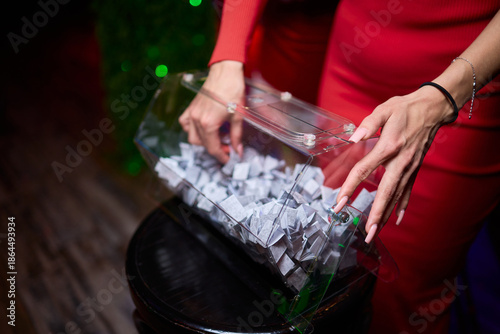 Guests select raffle tickets eagerly, People reach into box to pick lucky raffle slip, Participants eagerly reach into transparent container for their chance to win prize