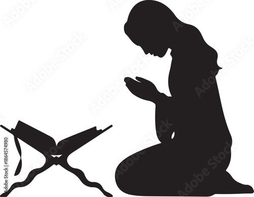 Silhouette of person praying with open book on the ground
