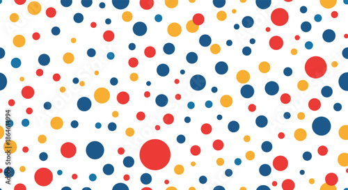 Seamless abstract pattern of colorful polka dots in red blue and yellow of various sizes scattered on a white background.