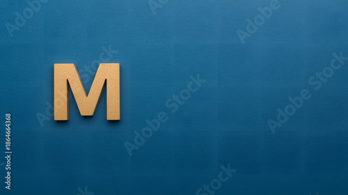 Letter M on Blue: A single, elegantly crafted letter M rests against a striking blue backdrop, creating a clean and minimalist composition that speaks volumes.