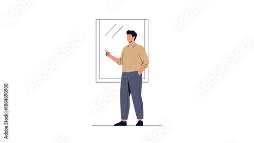 Stylish young man standing indoors near a window using a smartphone