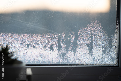Fotografi Water droplets form on a windowpane, showing high humidity levels inside a room