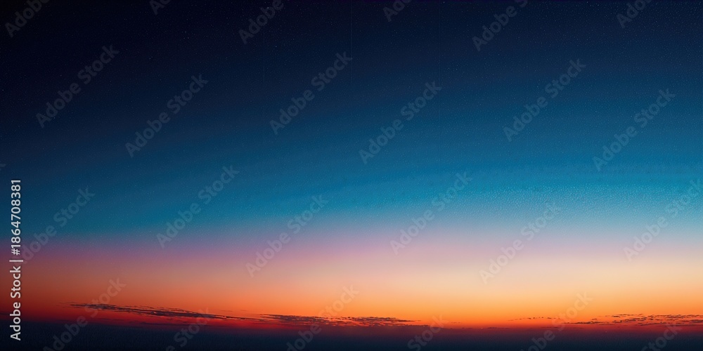 Fototapeta premium Sunset Horizon: The sky transitions from a deep, mesmerizing blue to vibrant orange hues, creating a tranquil and picturesque panorama. 