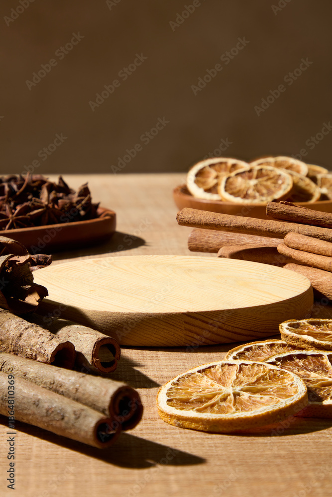 Fototapeta premium Scene of herbal tea ingredients such as cinnamon and dried citrus on wooden surface. Brown background and blank space for healthy beverage branding and editorial use