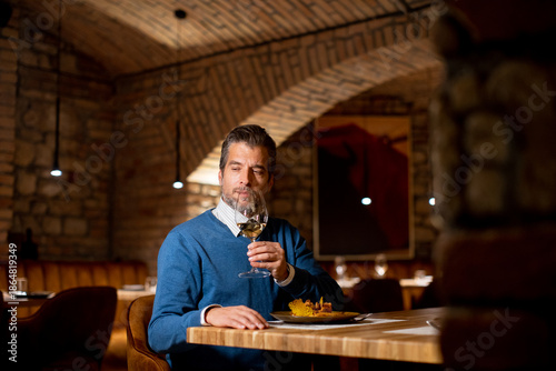 Man enjoys wine while seate...