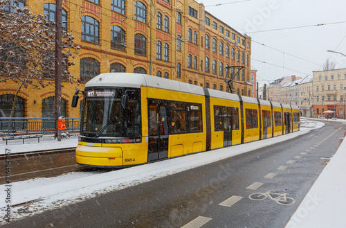 Berlin Wintereinbruch mit Schneefall in Berlin Schöneweide / Edisonstrasse, Langer Zug der Metrotram der Linie M17 hält im winterlichen Berlin im Bezirk Treptow Köpenick