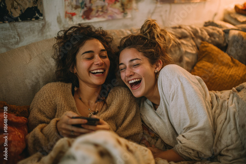 Candid Photo of Diverse Female Friends Laughing and Collapsing on Couch at Home