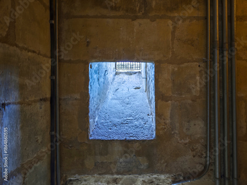 Картината върху платно Ventana con barrotes en un grueso muro de piedra
