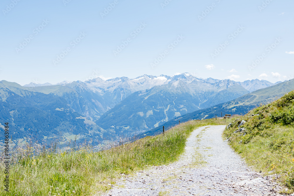Fototapeta premium Winding mountain path leading to majestic peaks in the alps