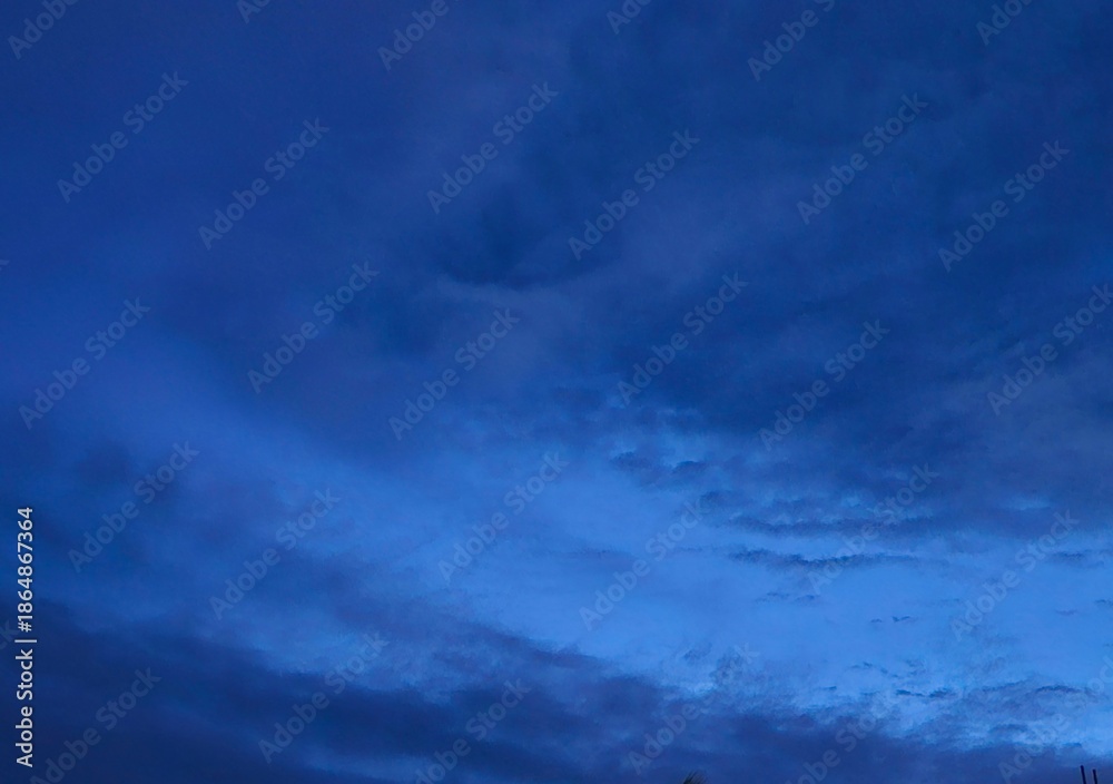 Fototapeta premium storm clouds timelapseDark blue afternoon sky with grey clouds.House silhoute with dark blue sky in evening after sundown