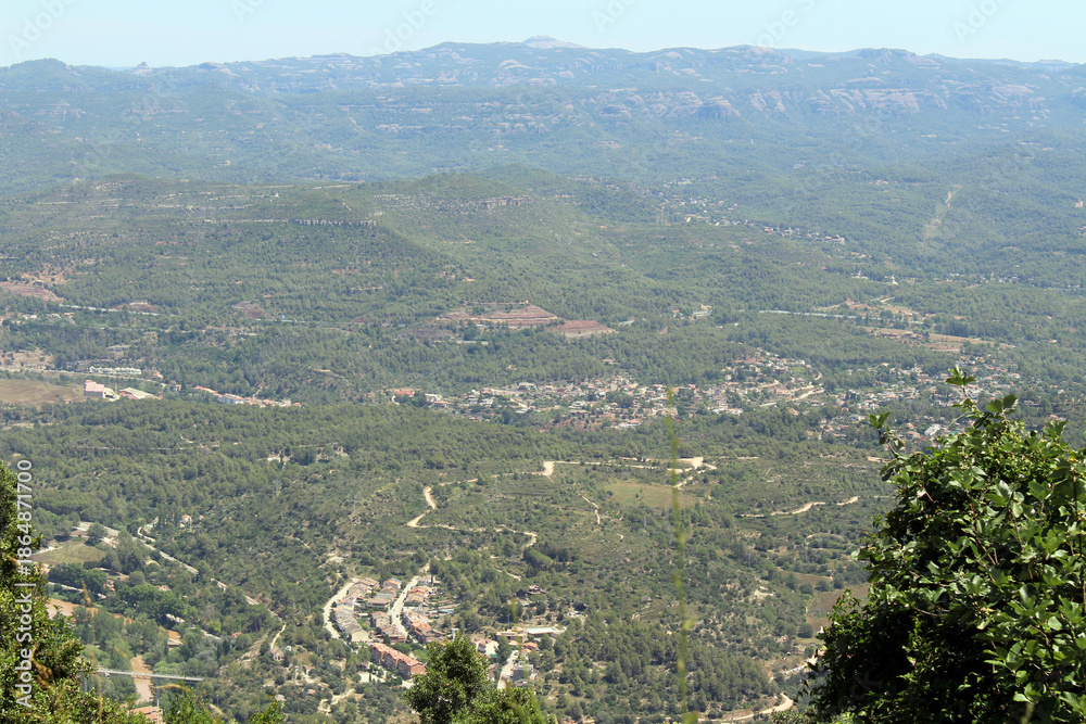Obraz premium View overlooking the town and surrounding landscape from Montserrat monastery in Catalonia, Spain, taken in July 2024.