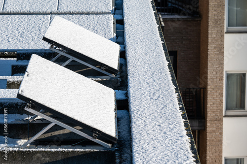 Snow-covered solar panels on flat roofs