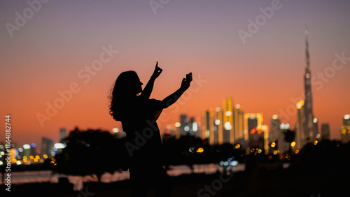 Εκτύπωση καμβά city lights Dubai skyline with gradient orange sky at sunset and silhouette of a