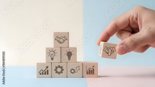 Building Blocks of Success Hand places partnership icon atop business strategy pyramid, representing collaboration, innovation, and growth for corporate development