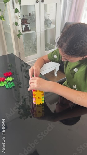 garota com autismo faz atividade com peças coloridas em casa 