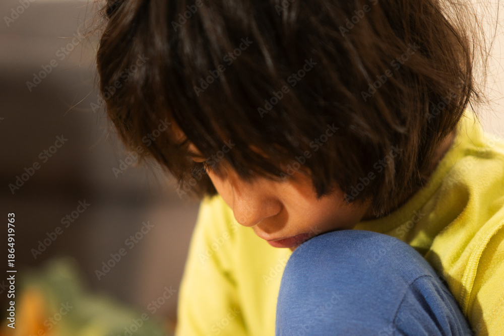 Obraz premium Young child contemplating and looking down with pensive expression