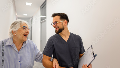 Tableau sur toile Male ophthalmologist and elderly patient laughing while discussing medical repor
