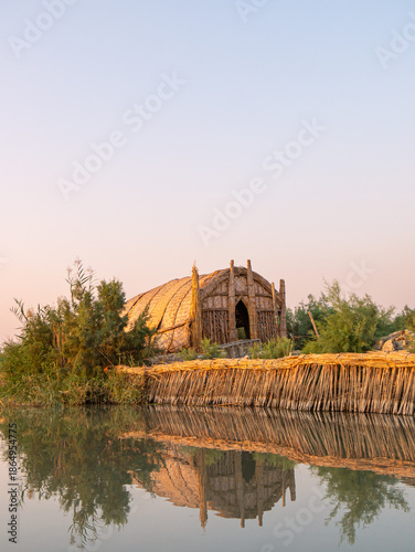 Traditional Sumerian reed house in the Iraqi marshes during sunset