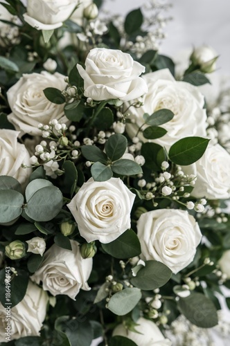 Wedding Bouquet With White Roses and Greenery Displayed Indoors in Bright Lig...