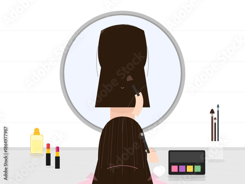 Woman applies makeup in front of a mirror with various tools and products on the table during the day