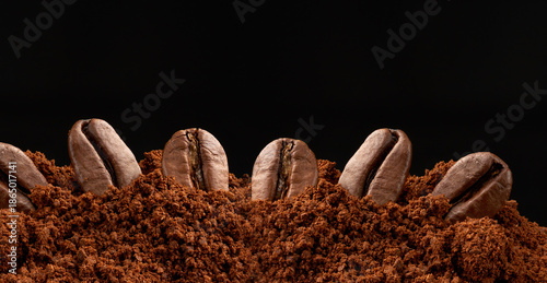 Photos Roasted coffee beans in ground coffee on a black background