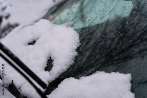 Melting snow on cars windshield close up shot.
