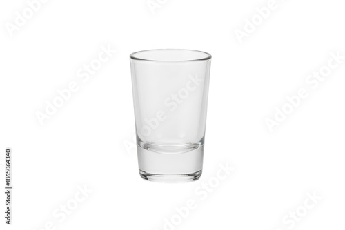 A solitary clear shot glass illuminated, perfect for showcasing beverages or ingredients