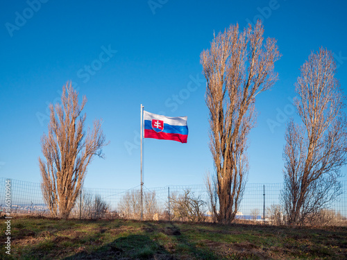 Canvas Print Slovak national flag flying above a historic concrete military bunker in Petržalka, Bratislava, Slovakia, part of preserved prewar and Cold War fortifications