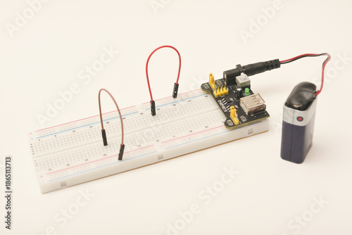 A solderless board for electronics with a battery. A breadboard for experiments in electronics.