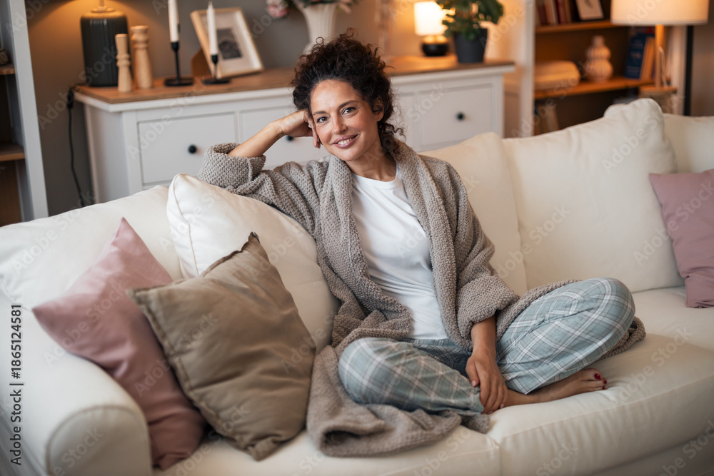 Obraz premium Cozy Woman Relaxing On White Couch In Comfortable Robe At Home