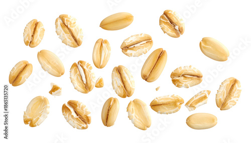 Isolated, close-up photograph of scattered, golden-brown rolled oat groats on black