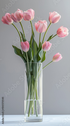 Różowe tulipany w szklanym wazonie na jasnym tle, minimalistyczna dekoracja wnętrza i wiosenny nastrój. © Henryk Guziak