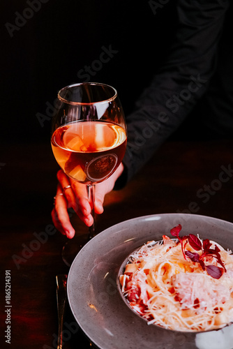Fine dining experience with wine and pasta in a cozy restaurant setting during the evening