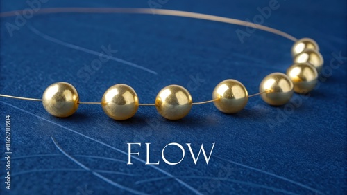 A string of five perfectly polished gold beads arranged in a line on a textured blue surface, showcasing elegance and luxury.