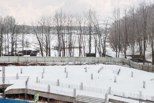 Frozen construction site in winter with unfinished concrete foundation, crisis concept