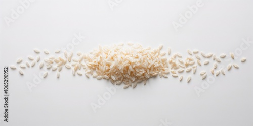 Uncooked rice flakes arranged on a plain white surface for culinary or packaging purposes, neutral context
