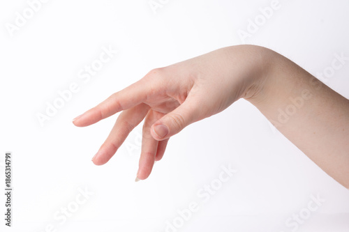 Hand reaching out elegant with extended fingers against white background